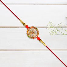 Intricately Designed Circular Rakhi With Multicolor Accents And Red Thread For Rakshabandhan
